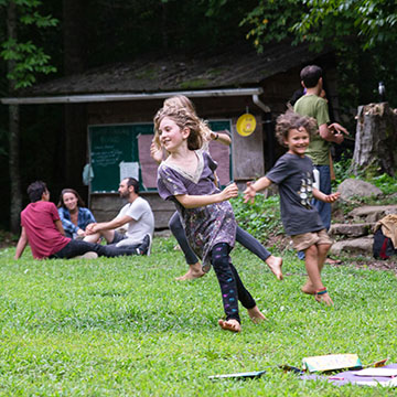 Children playing tag on the Earthaven village green