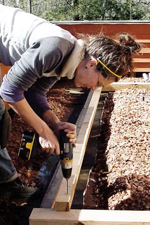 Earthaven member constructing a building