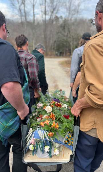Pall bearers carrying a body to a grave